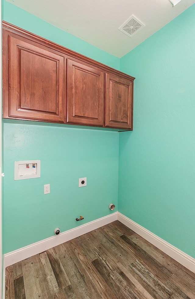 laundry area featuring gas dryer hookup, cabinets, washer hookup, dark hardwood / wood-style flooring, and hookup for an electric dryer