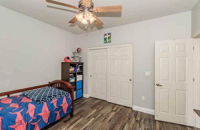 bedroom with dark wood-type flooring, ceiling fan, and a closet