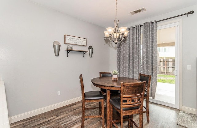 dining space featuring hardwood / wood-style floors and a notable chandelier