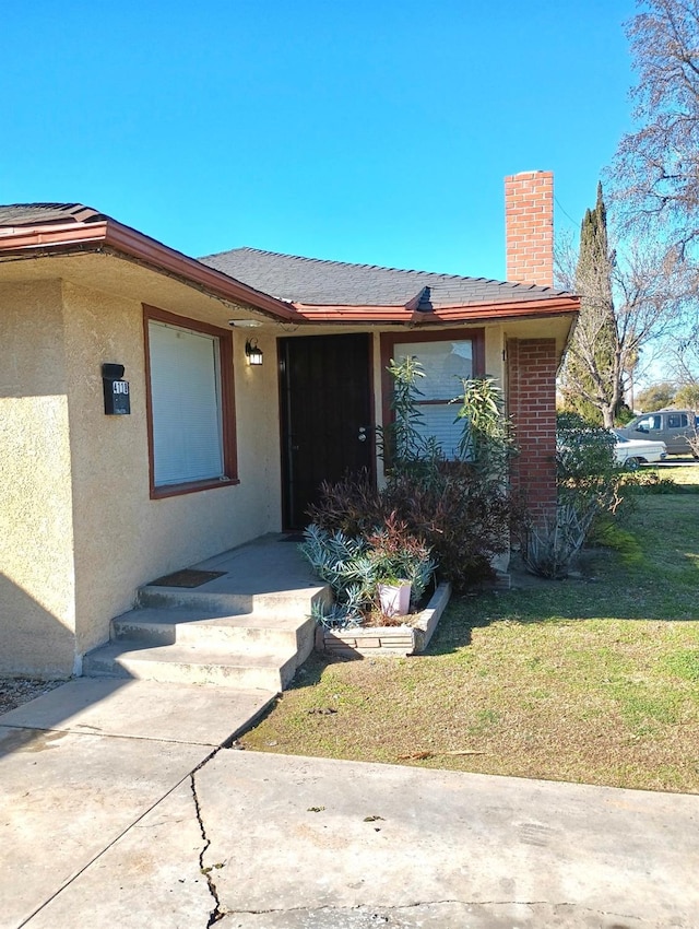 property entrance featuring a lawn