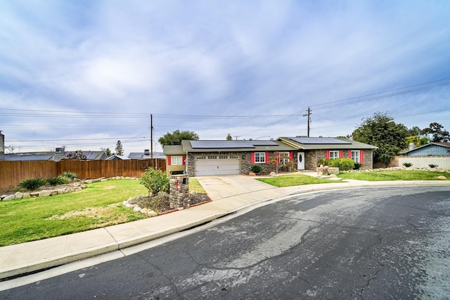 ranch-style home with a garage, a front lawn, and solar panels