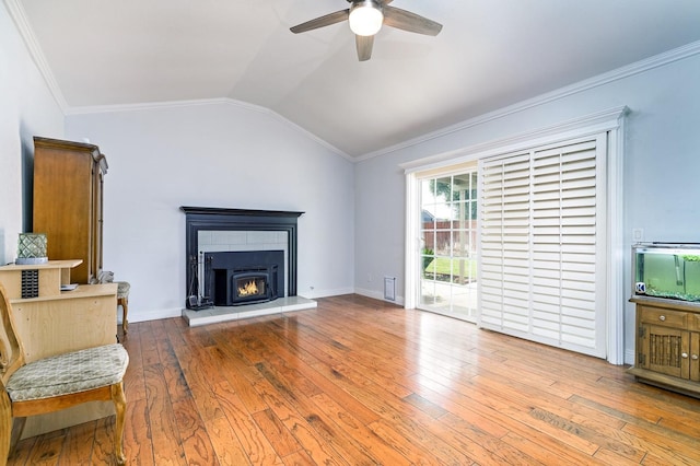 living room featuring ceiling fan, ornamental molding, wood-type flooring, and vaulted ceiling