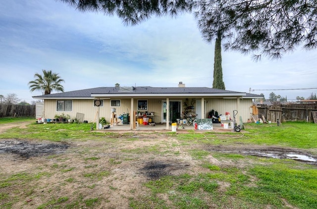 rear view of house with a patio area and a lawn