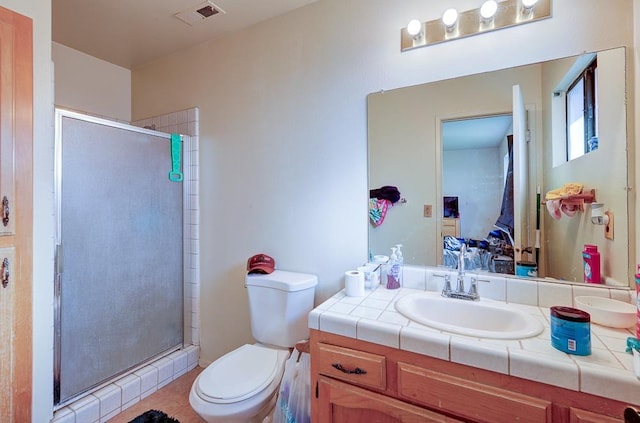 bathroom with vanity, a shower with shower door, and toilet