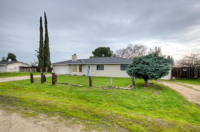 single story home featuring a garage and a front yard