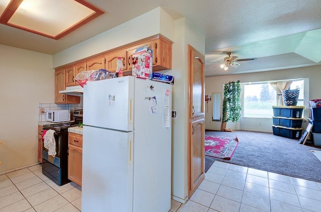 kitchen featuring white appliances, ceiling fan, backsplash, a textured ceiling, and light colored carpet