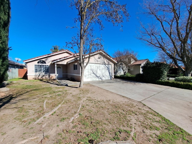 view of front of house with a garage, a tiled roof, concrete driveway, and stucco siding