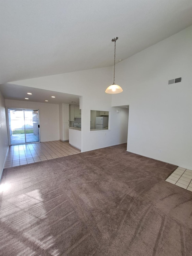 unfurnished room with light carpet, light tile patterned floors, visible vents, and high vaulted ceiling