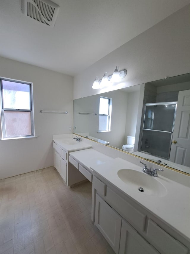 full bath featuring toilet, a stall shower, vanity, and visible vents