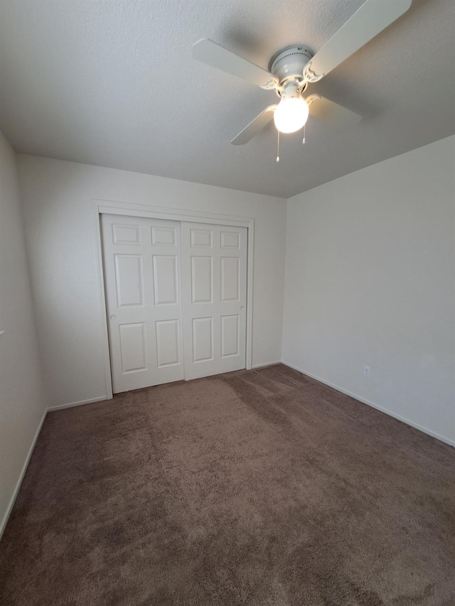 unfurnished bedroom with a closet, carpet flooring, ceiling fan, and a textured ceiling