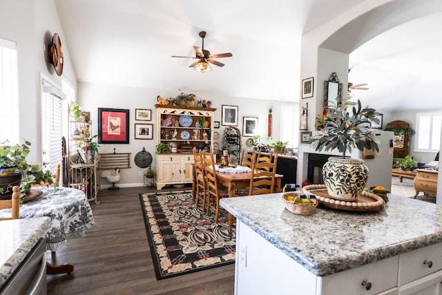 kitchen featuring lofted ceiling, dark wood-type flooring, ceiling fan, white cabinetry, and light stone countertops