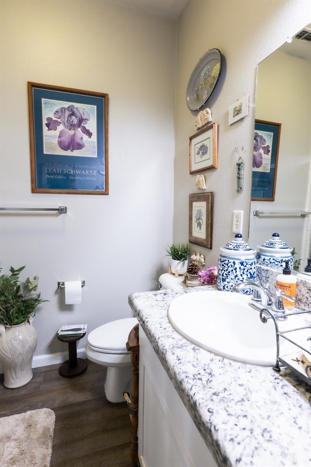 bathroom featuring vanity, toilet, and hardwood / wood-style floors