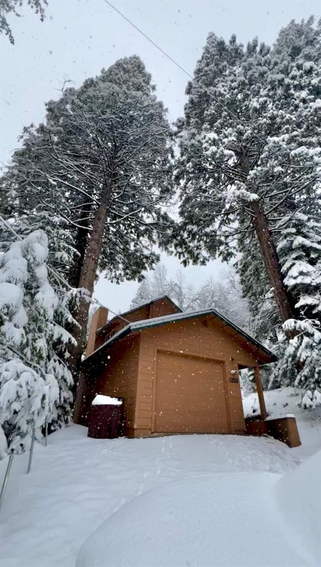 view of snow covered exterior featuring a garage