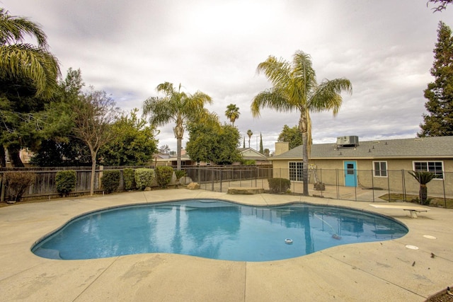 view of swimming pool featuring central air condition unit and a patio area