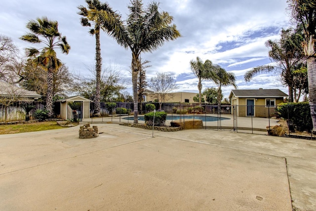 view of community featuring a pool, a patio, and a storage unit