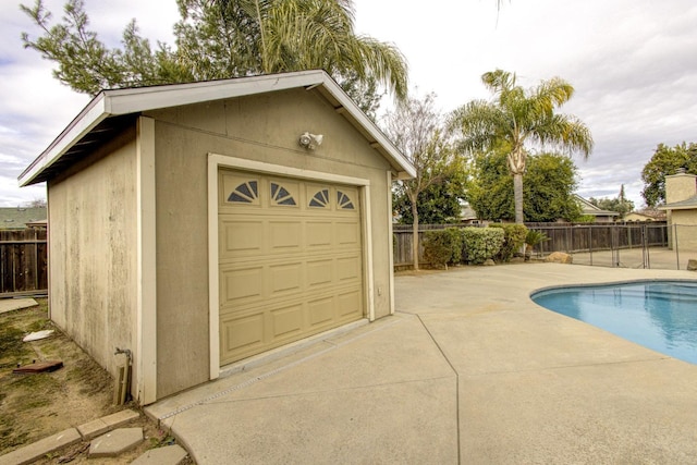 view of pool with a garage and an outdoor structure