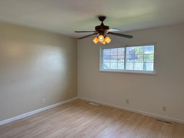 unfurnished room featuring light hardwood / wood-style flooring and ceiling fan