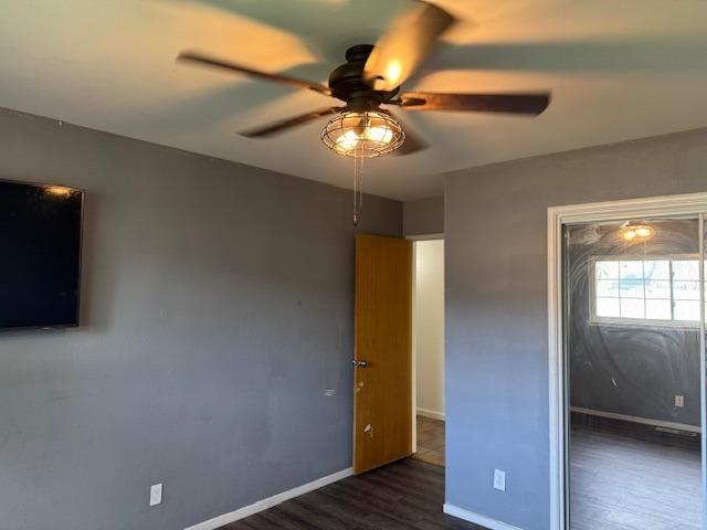 unfurnished bedroom featuring a closet, dark hardwood / wood-style floors, and ceiling fan