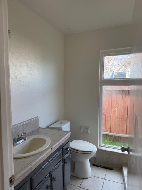 bathroom featuring tile patterned floors, toilet, and vanity