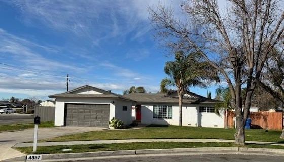 single story home with a front yard and a garage