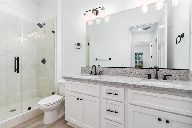 bathroom with vanity, hardwood / wood-style flooring, a shower with shower door, and toilet