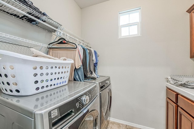 washroom featuring separate washer and dryer, light tile patterned floors, and cabinets