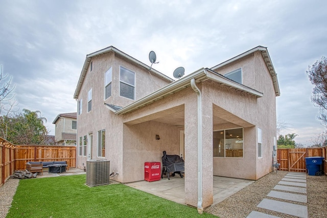 back of house featuring a yard, outdoor lounge area, a patio, and central air condition unit