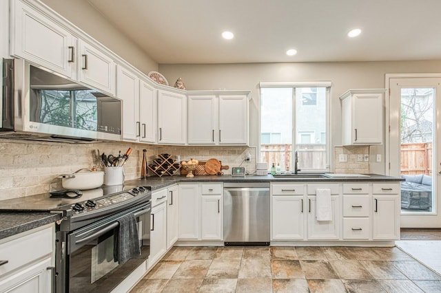 kitchen featuring white cabinetry, stainless steel appliances, sink, and backsplash