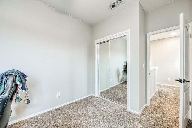 unfurnished bedroom featuring light colored carpet and a closet