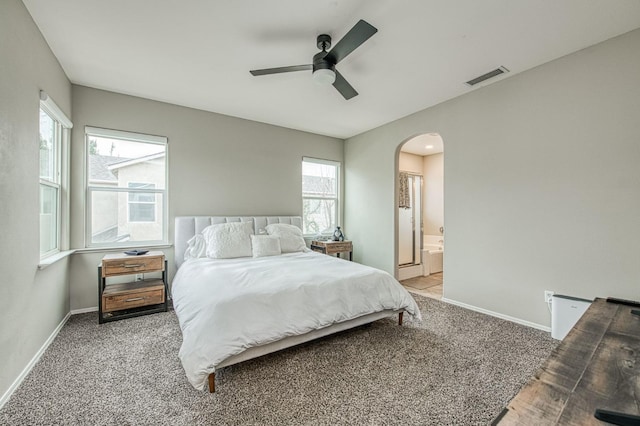 bedroom with ceiling fan, connected bathroom, carpet flooring, and multiple windows