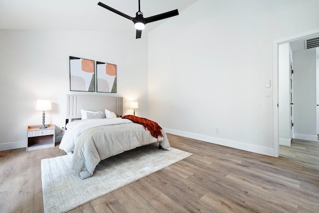 bedroom featuring light hardwood / wood-style flooring, high vaulted ceiling, and ceiling fan