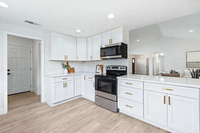 kitchen featuring white cabinetry, tasteful backsplash, stainless steel appliances, and light hardwood / wood-style flooring