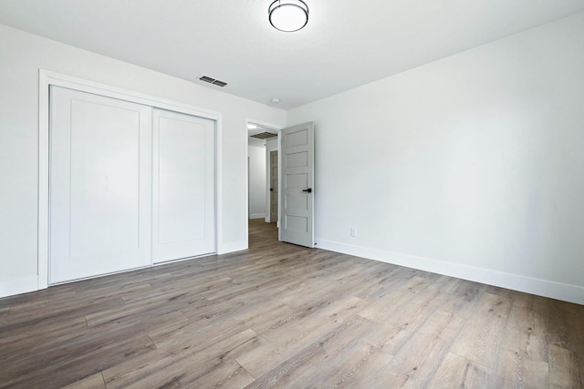 unfurnished bedroom with light hardwood / wood-style floors and a closet