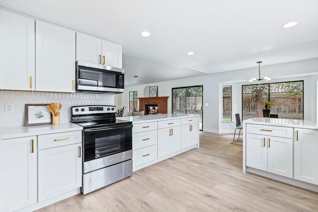 5017 W Locust Ave, Fresno, CA 93722 - kitchen featuring appliances with stainless steel finishes, a chandelier, light countertops, white cabinets, and backsplash