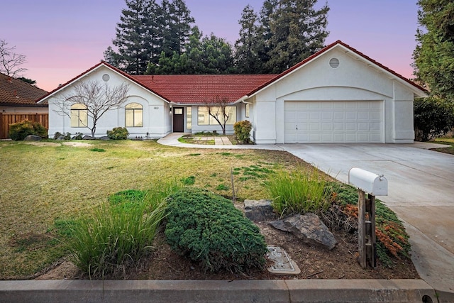 5017 W Locust Ave, Fresno, CA 93722 - view of front facade featuring a tile roof, concrete driveway, a front yard, stucco siding, and an attached garage