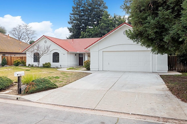 5017 W Locust Ave, Fresno, CA 93722 - view of front of property featuring a tile roof, stucco siding, concrete driveway, and a garage