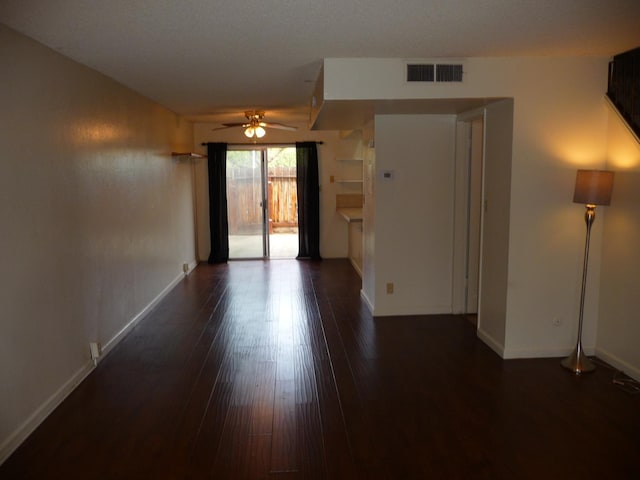 unfurnished room featuring dark wood-type flooring and ceiling fan