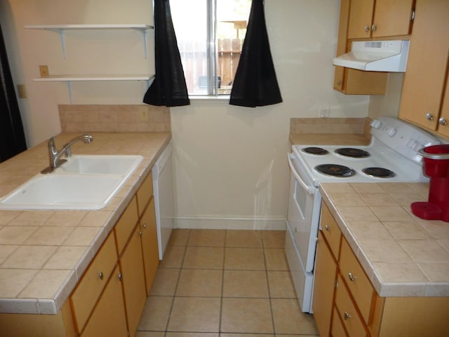 kitchen with sink, tile countertops, light tile patterned floors, kitchen peninsula, and white appliances