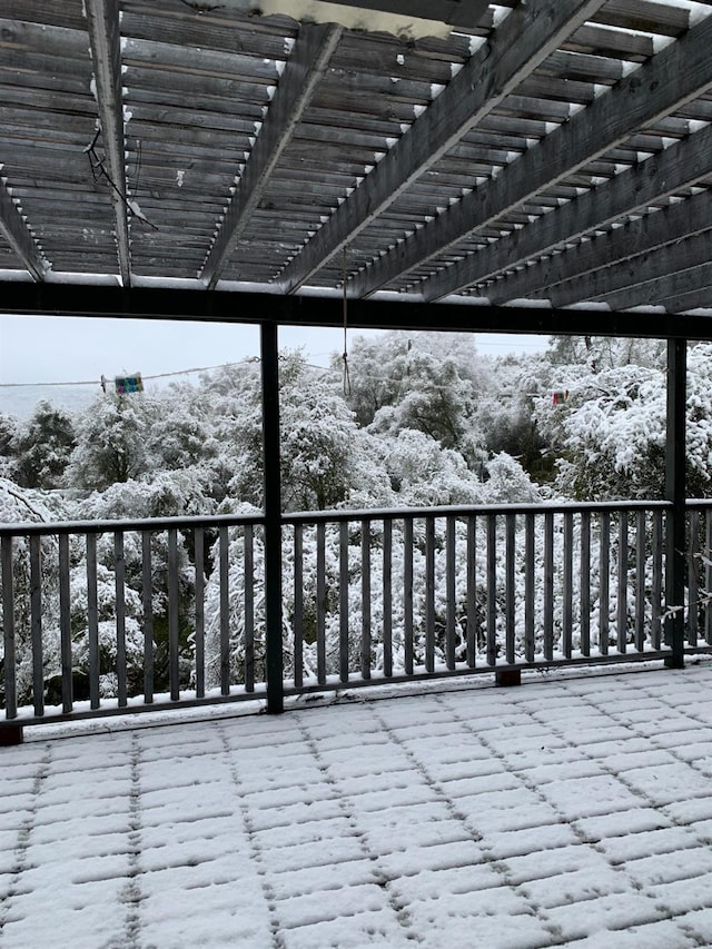 snow covered deck with a pergola