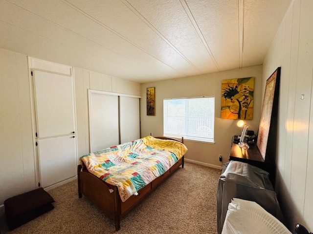 carpeted bedroom with a closet, a textured ceiling, and wood walls