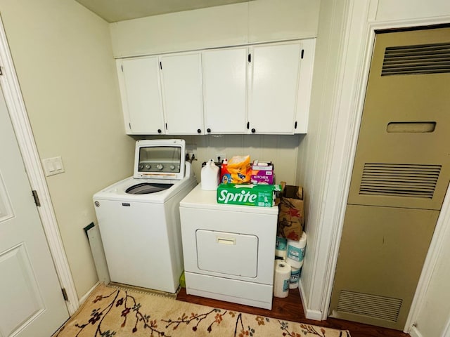 washroom featuring independent washer and dryer, cabinets, and light hardwood / wood-style floors