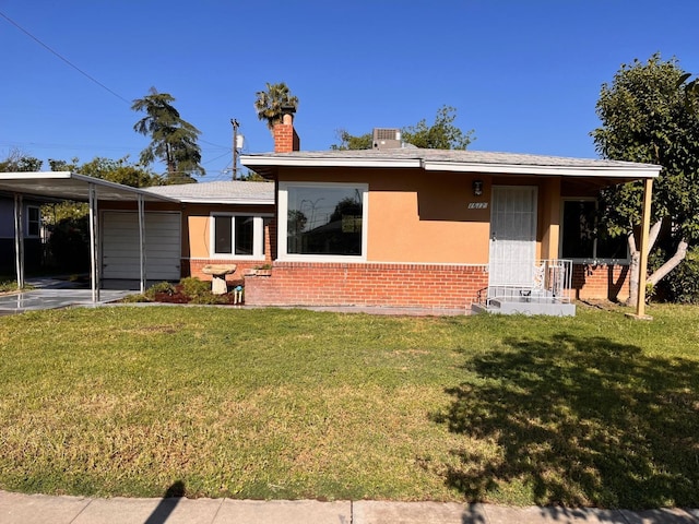 back of property with a carport and a yard