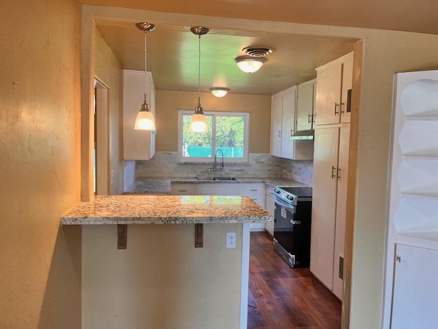 kitchen featuring stainless steel range with electric stovetop, sink, a kitchen breakfast bar, and white cabinets