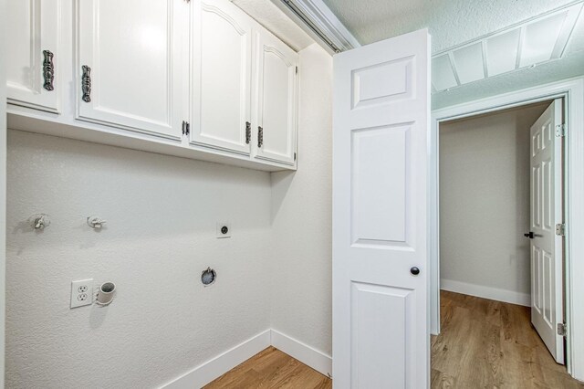 clothes washing area with cabinets, hookup for a gas dryer, light hardwood / wood-style floors, and hookup for an electric dryer