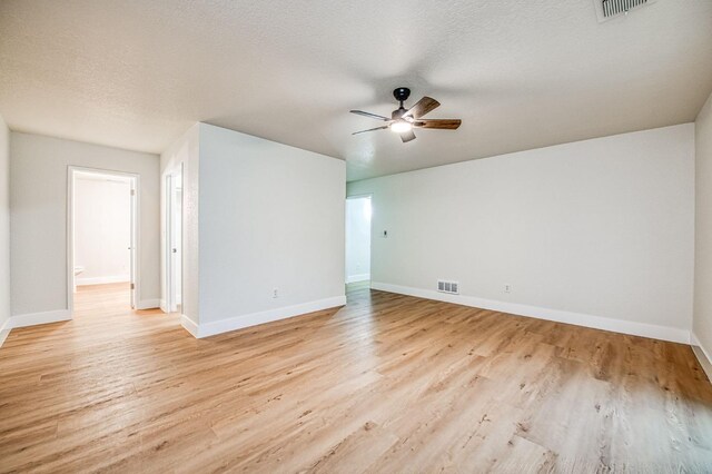 empty room with ceiling fan, light hardwood / wood-style floors, and a textured ceiling