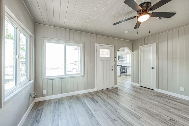 interior space with light wood-type flooring, ceiling fan, and wood ceiling