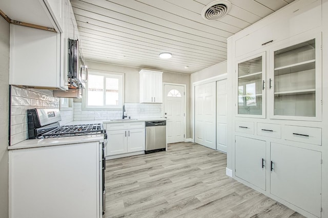 133 W Birch Ave, Pinedale, CA 93650 - kitchen featuring stainless steel appliances, white cabinetry, decorative backsplash, light countertops, and light wood-style floors