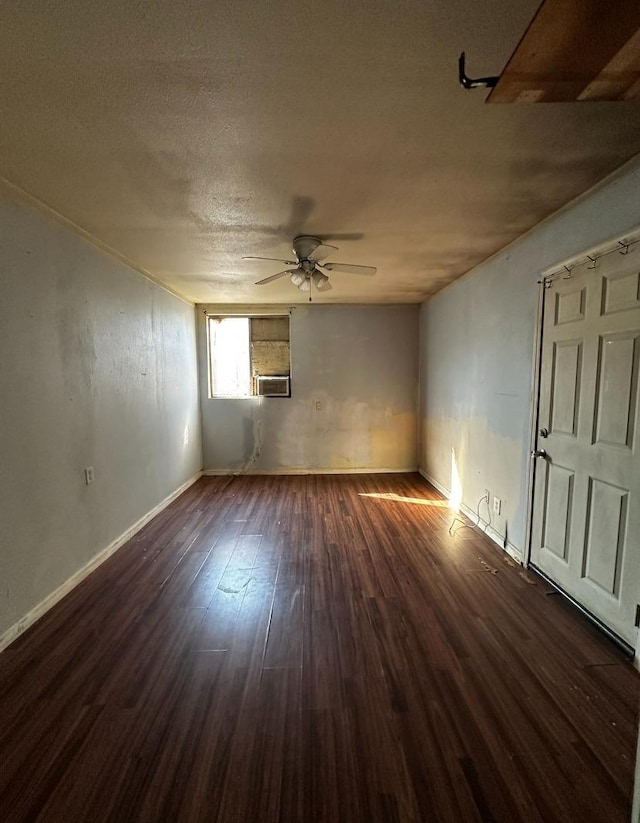 spare room featuring dark wood-type flooring, a textured ceiling, and ceiling fan