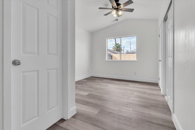 unfurnished bedroom featuring ceiling fan, lofted ceiling, light wood-type flooring, and a closet