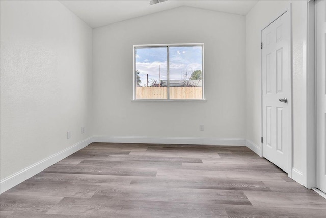 unfurnished bedroom featuring light hardwood / wood-style flooring and vaulted ceiling